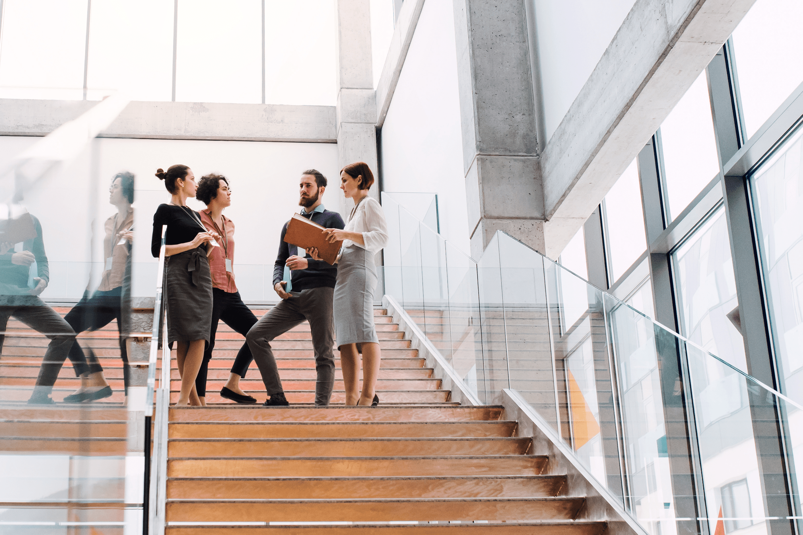 Group of young businesspeople walking down the stairs, talking.